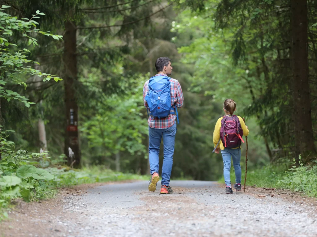 father and daugtehr hiking in woods