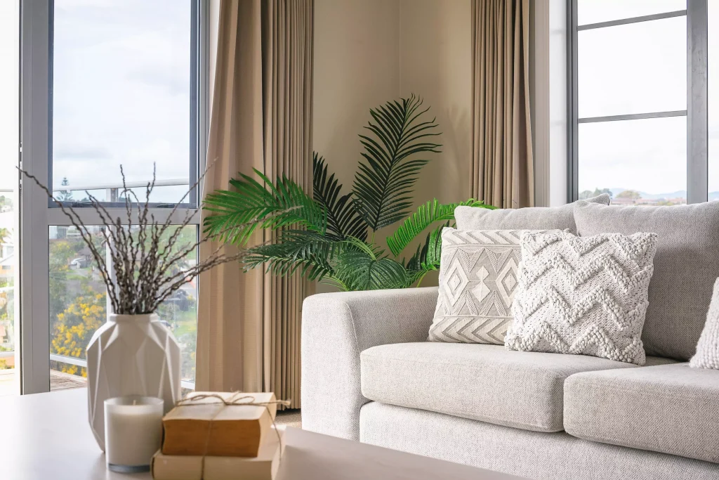 a white couch next to a plant