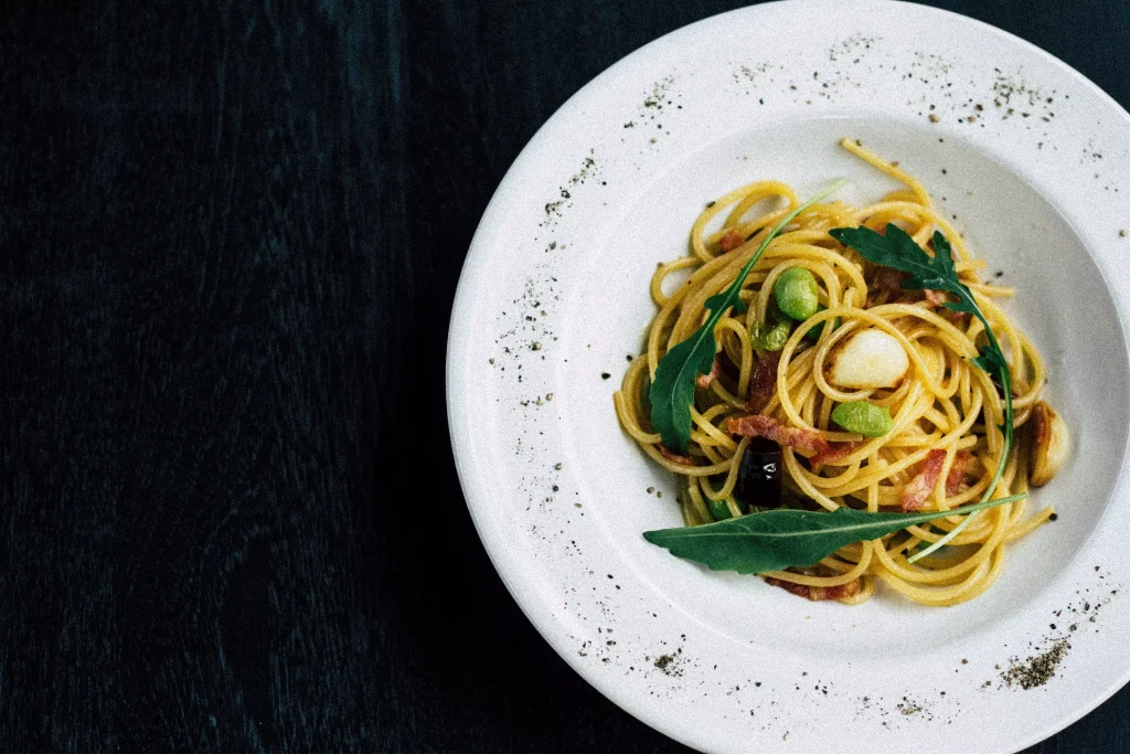 pasta with green salad in a white plate