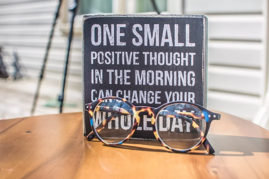 a board behind a pair of glasses on a table