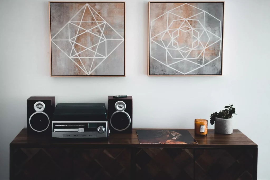 a stereo infront of a white wall with two violet pictures on it