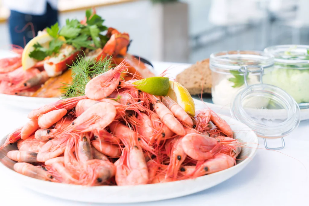 full plates of seafood and salad next to glass 