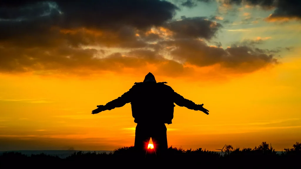 a shadow of a person infront of a sunset