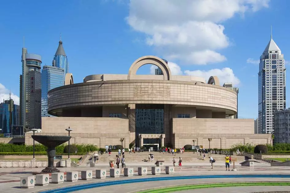 futuristic circle looking building in the middle of some skyscrapers