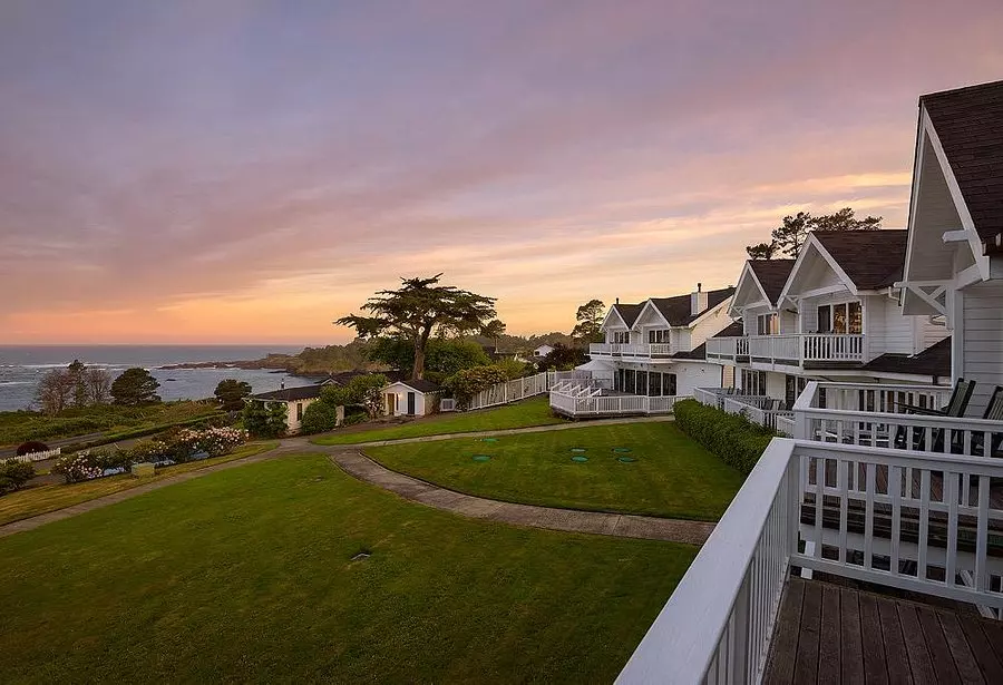 white houses on green fields photographed in sunset