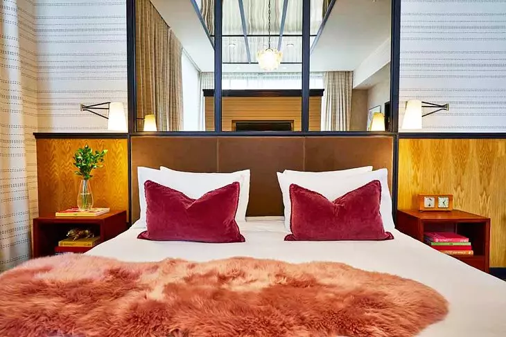 a hotel room with red pillows and a white bed