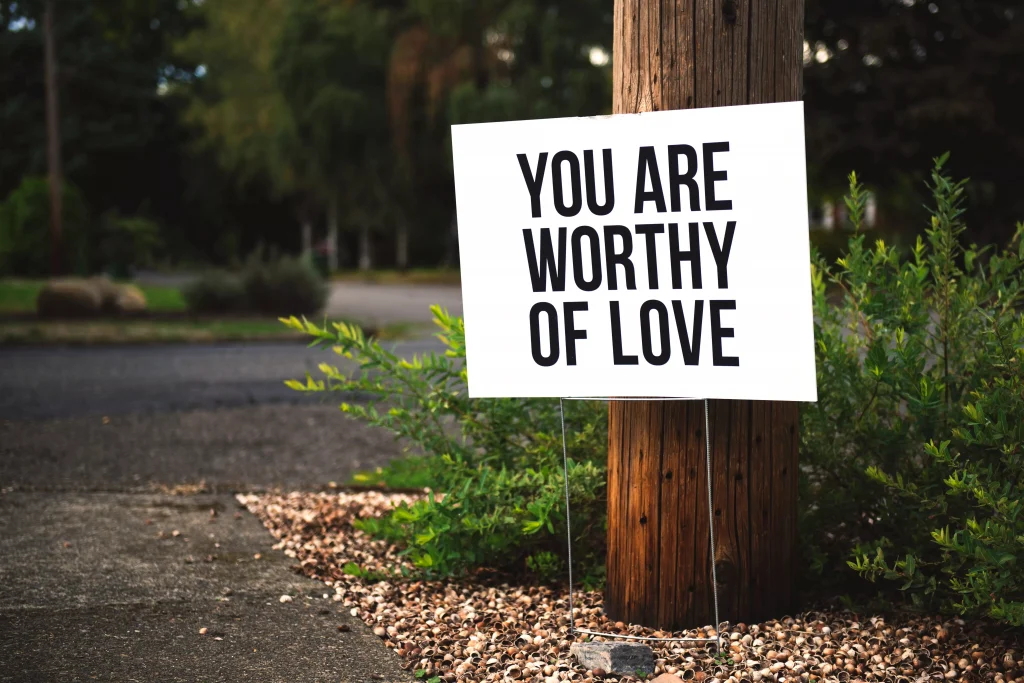 a sign on a tree that says you are worthy of love