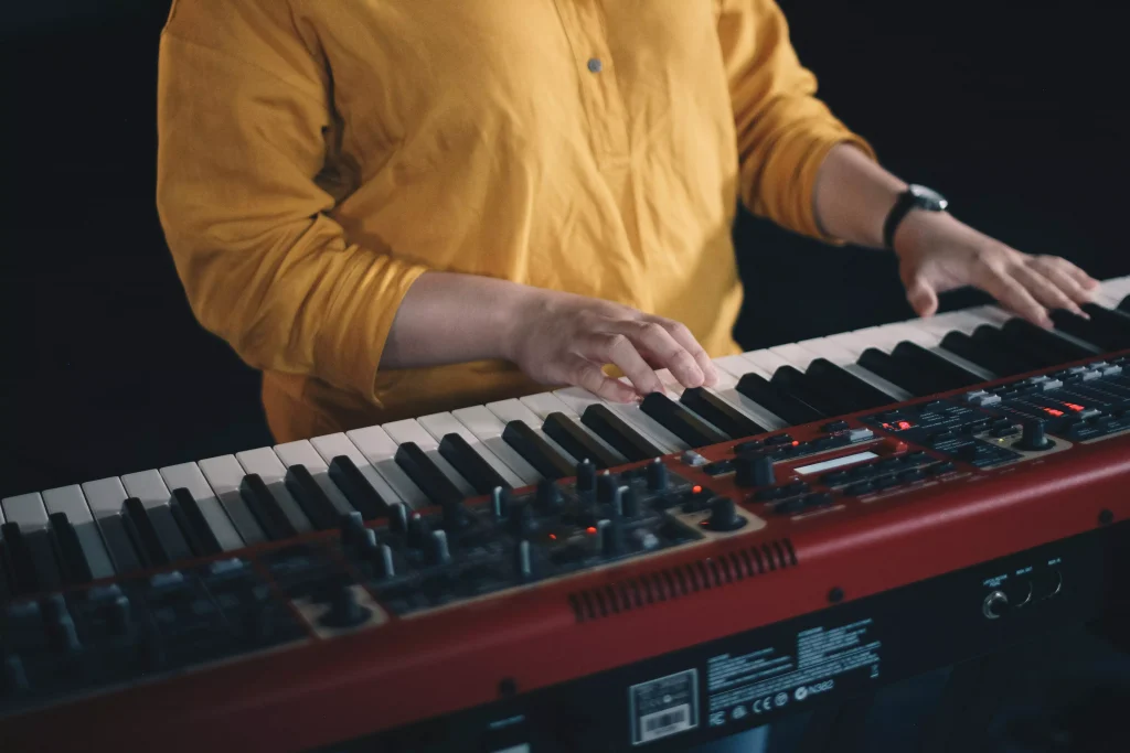 a man in a yellow shirt playin a red piano