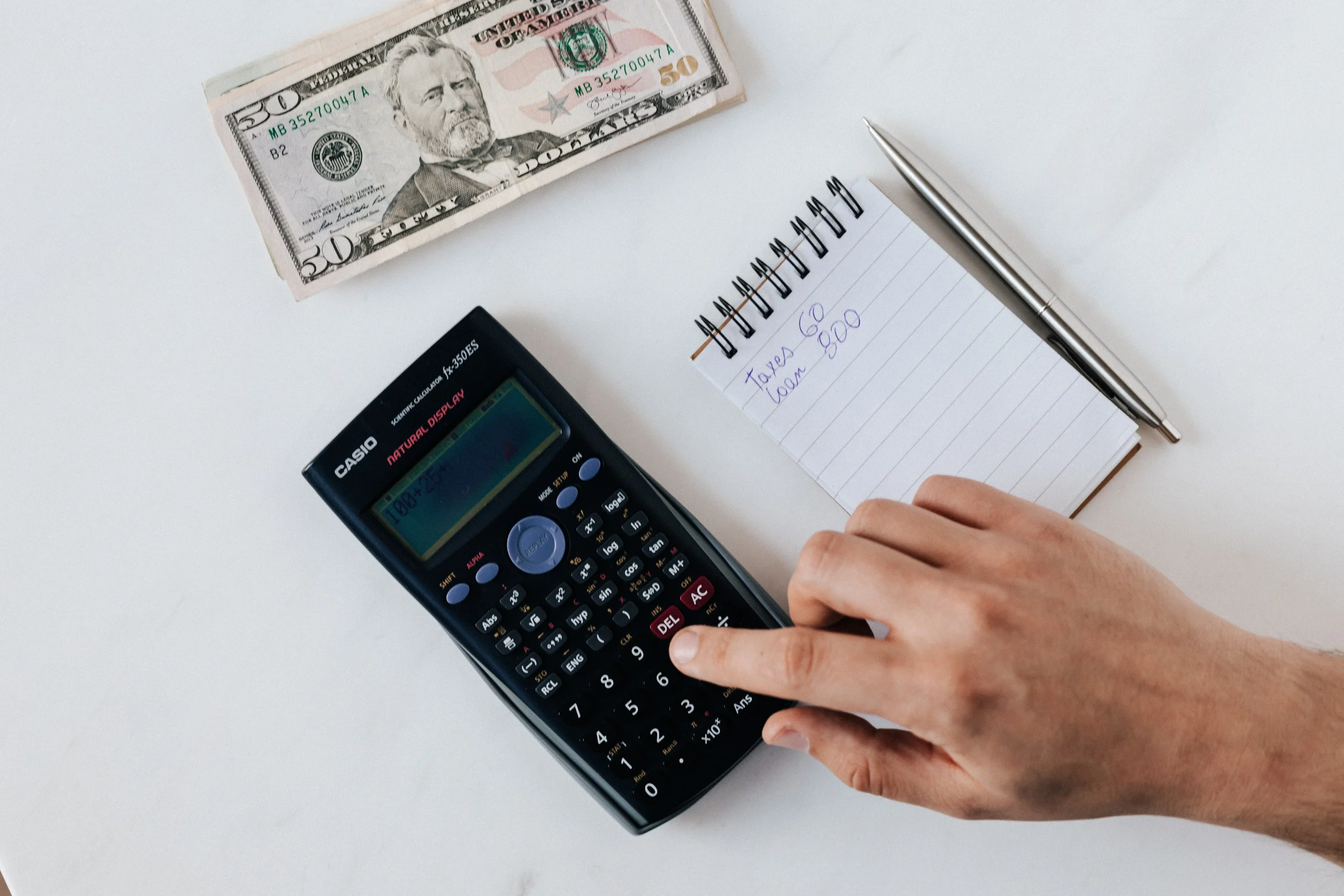 a notebook next to a calculator and money