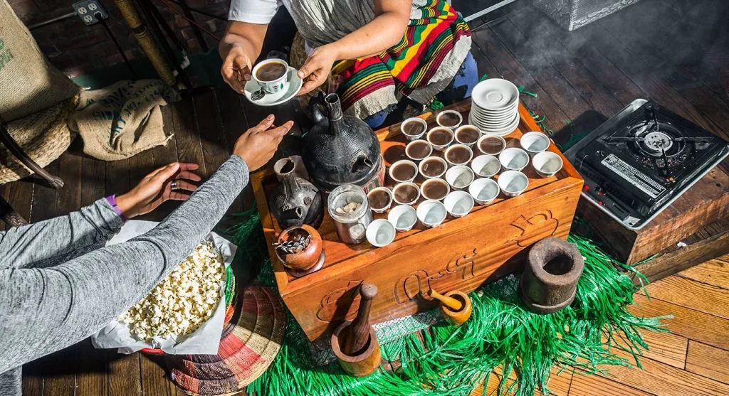 two people sitting at a table full of cups of drinks