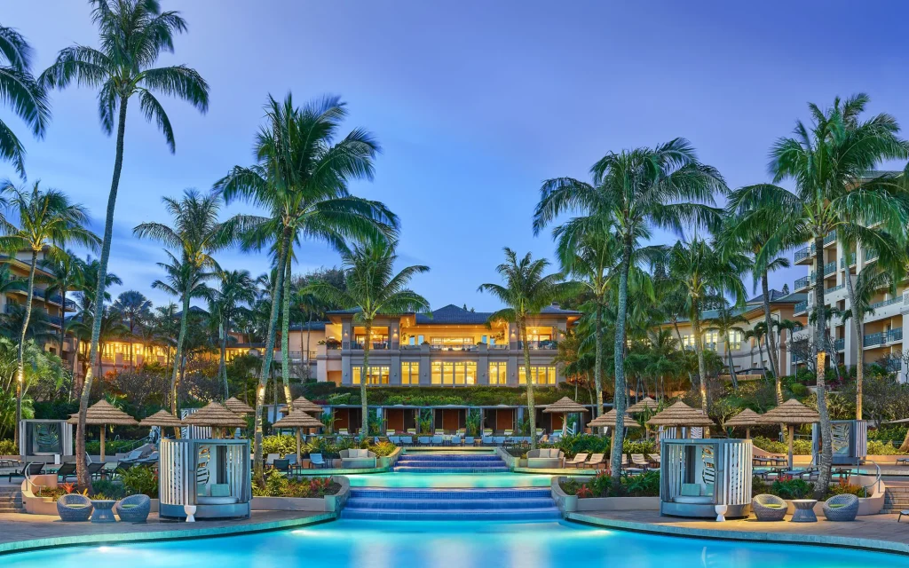 a luxury resort with pools betwenn palm trees