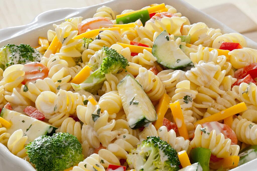 macaroni with green vegetables photographed in a white bowl