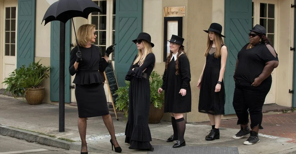 women in black clothes crossing a street