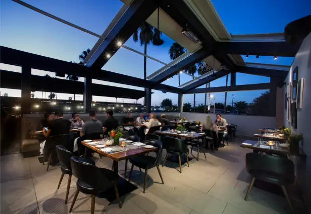 balcony of a restaurant and people on it photographed at night