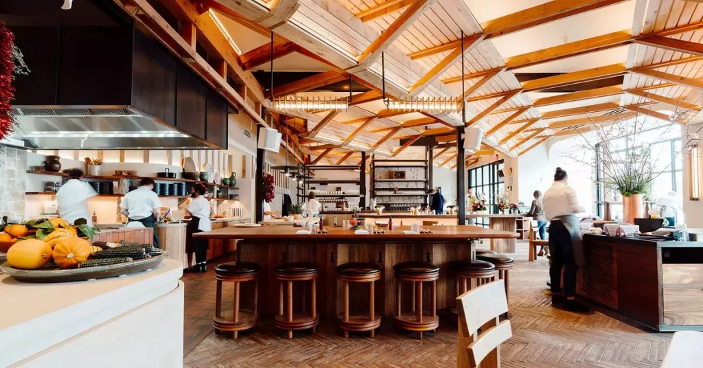 a restaurant with a lot of natural light coming from the windows photographed from the inside