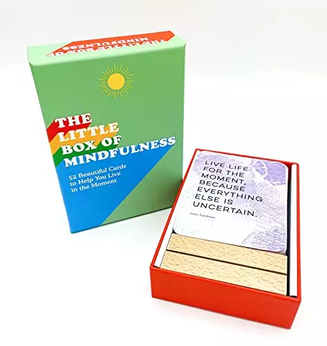 a green book next to a red box full of cards