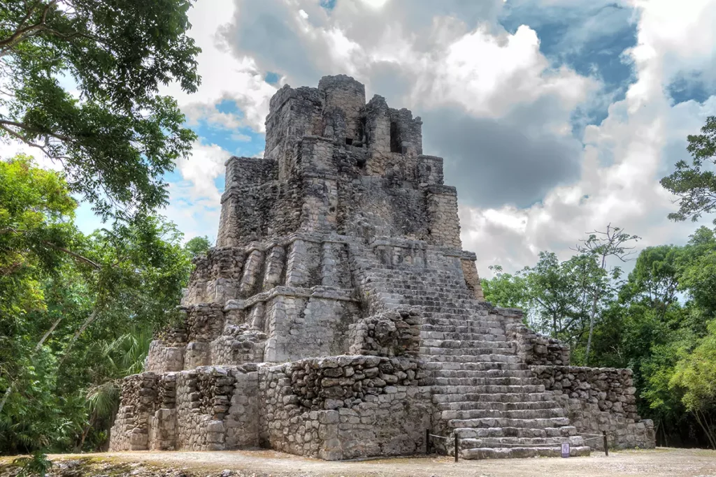 a stone structure in the middle of the forest