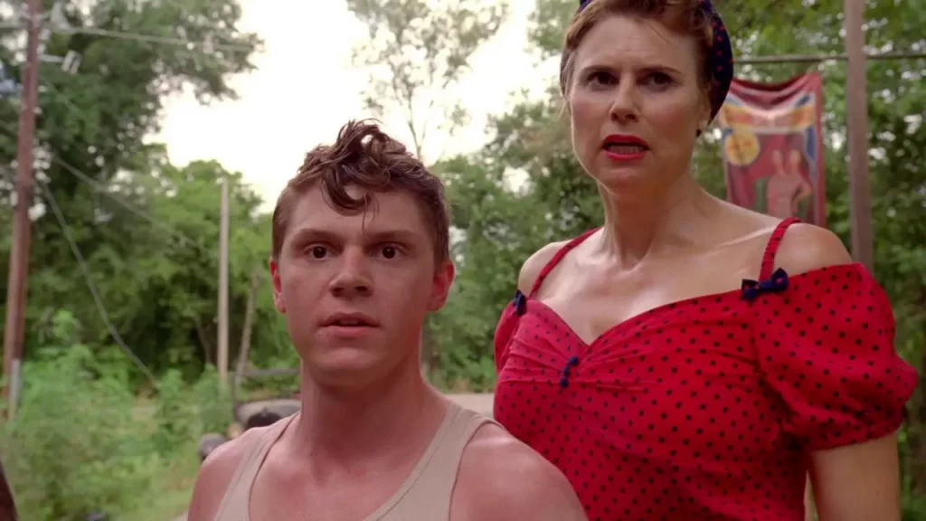 a guy in a tank top and a women in a red dress looking surprisengly at something