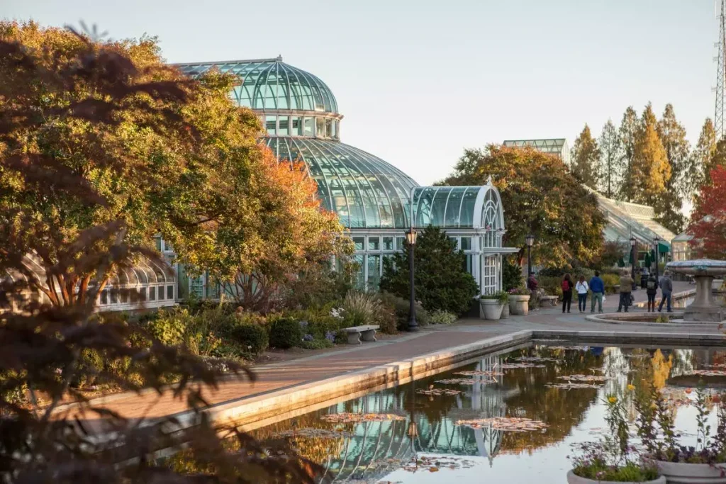 a glass structure building surrounded by trees and plants