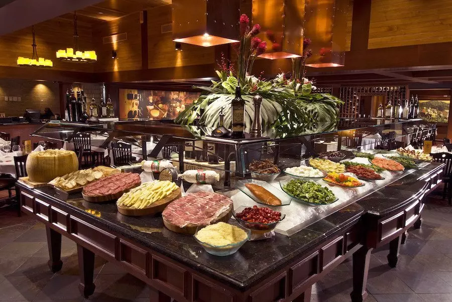 a bar full of food in a restaurant with brown walls