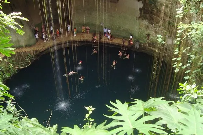 people swimming in a lake inside of the mountain