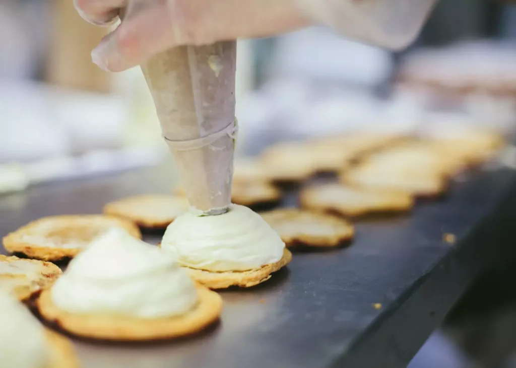 a person making cupcakes in a bakery