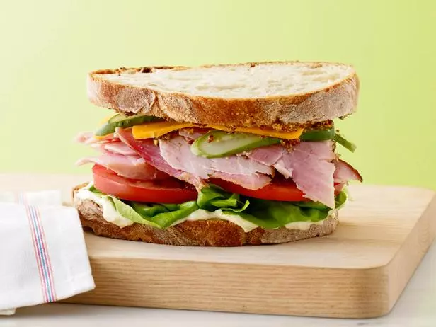 a sandwich on a wooden cutting board