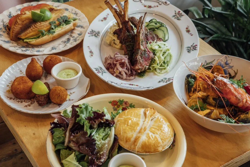 chicken with sauce next to bread and salad in a wooden bowl