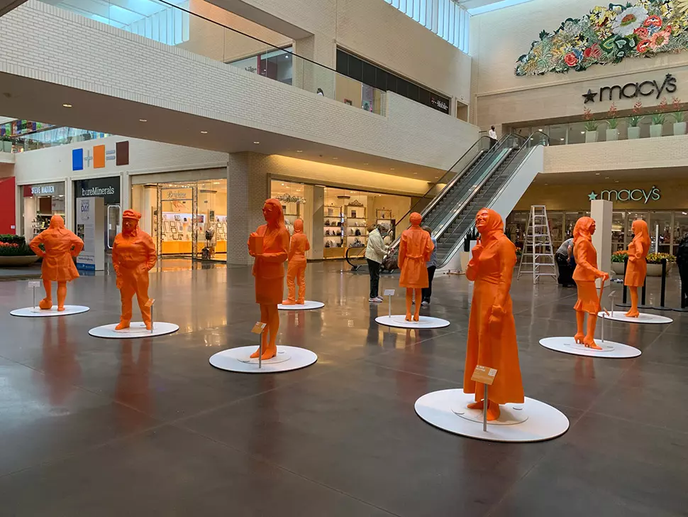 orange color statues in the middle of a shopping mall