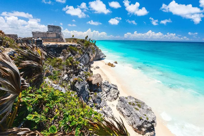 a beach next to some stone cliffs 