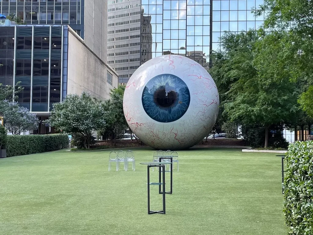 a giant white ball in the middle of a green field park