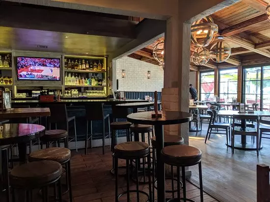 a bar with a tv and drinks next to the tv