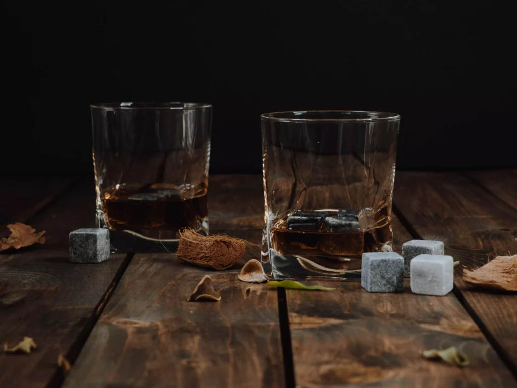 two glasses next to some ice cubes