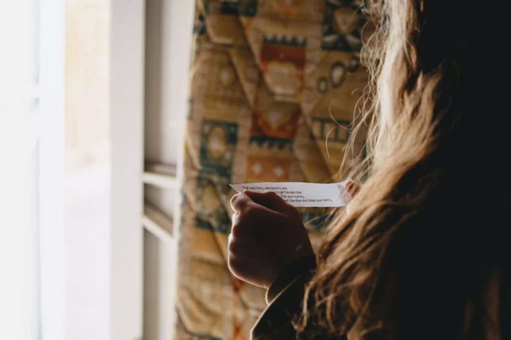 a girl with long hair reading a letter