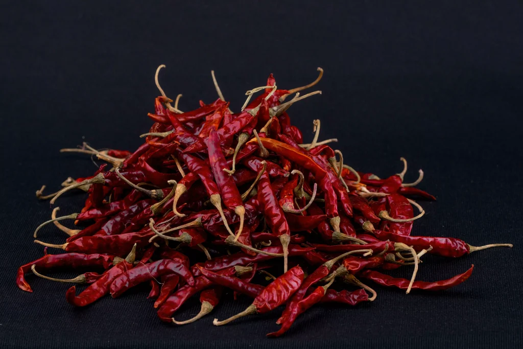 dark red peppers stacked on top of each other in a black color box