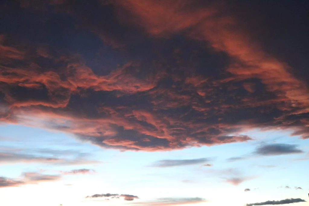 red clouds infront of a blue sky photographed from the ground