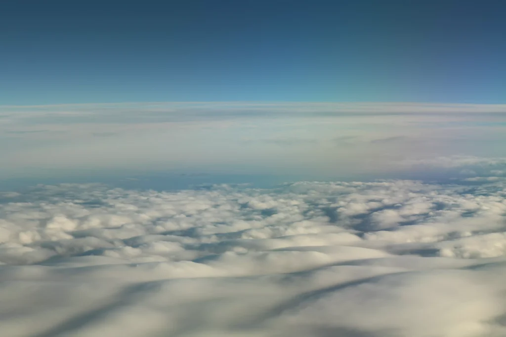 white clouds infront of a blue sky photographed from the airplane