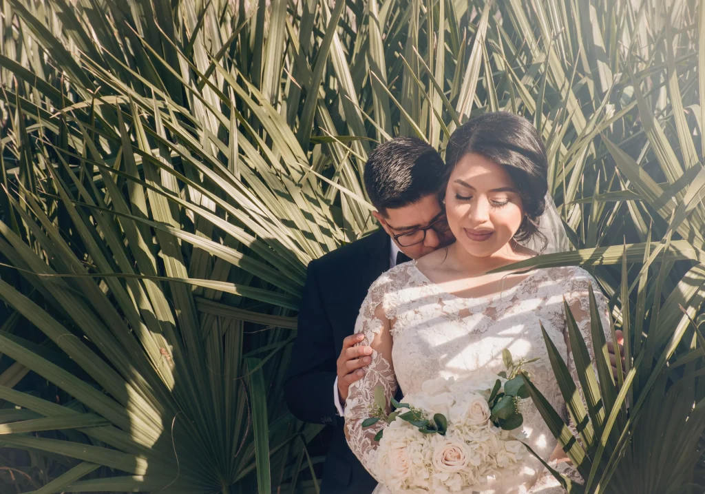 a man and a women in a dress behind some trees