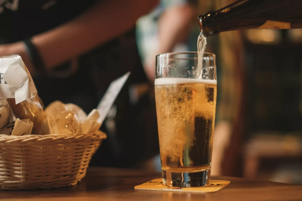 a person filling a glass with beer