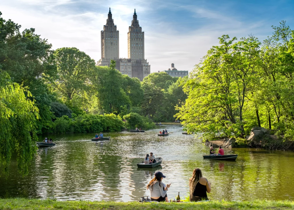 two girls siting near the river in the park