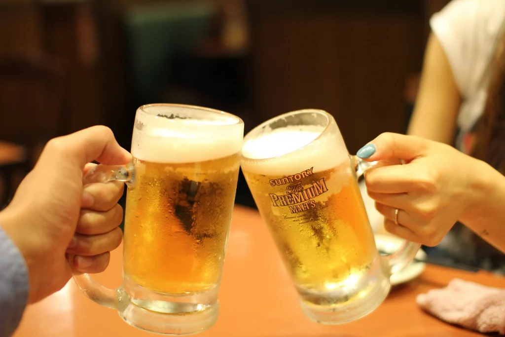 two person drinking beer together in a bar