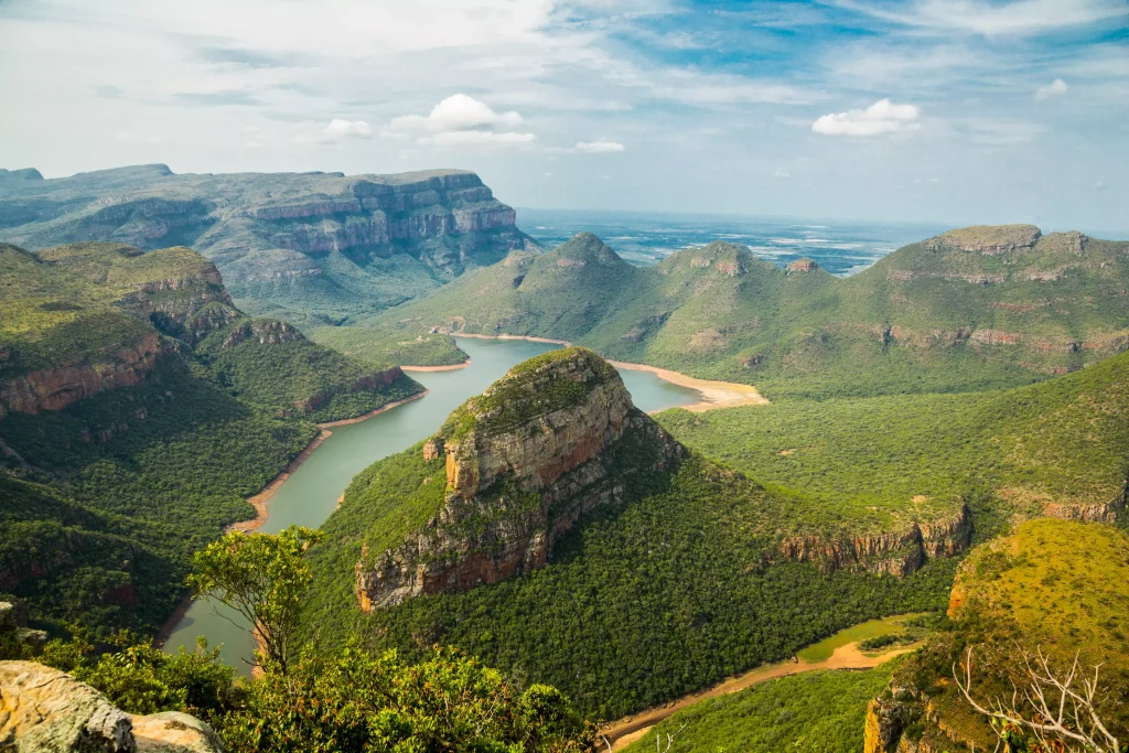 green mountains and a river next to them