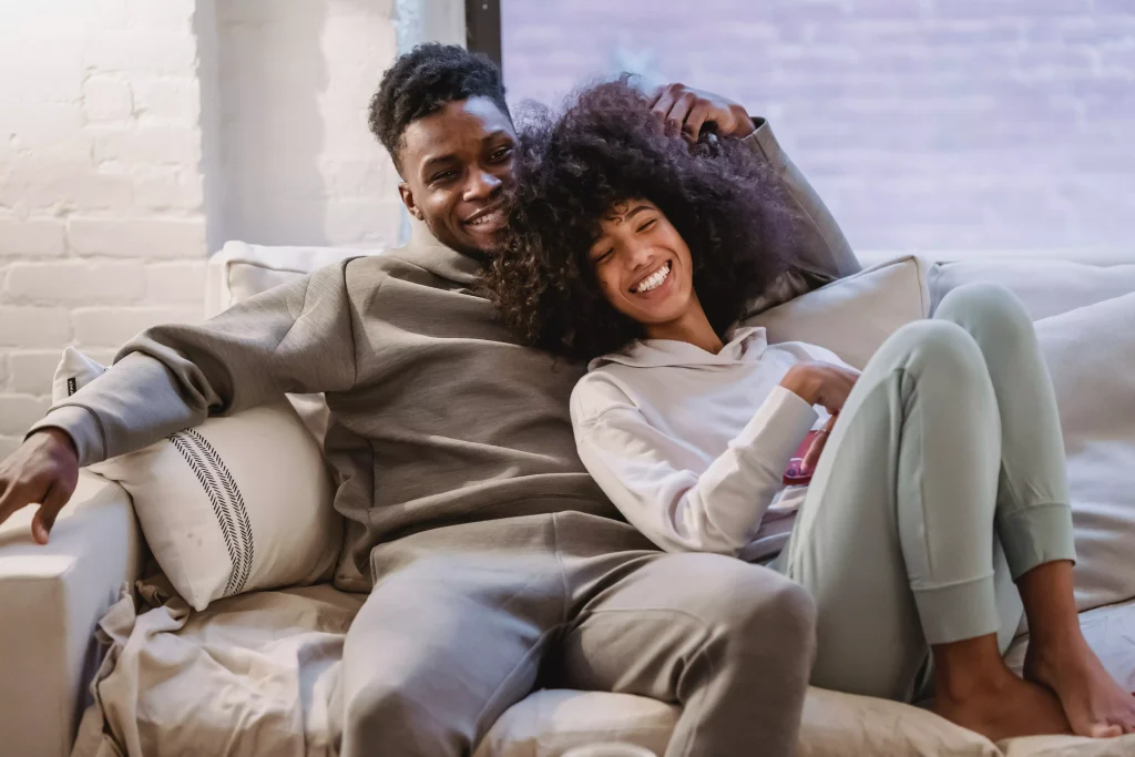 a guy and a girl in a grey shirt sitting on the couch