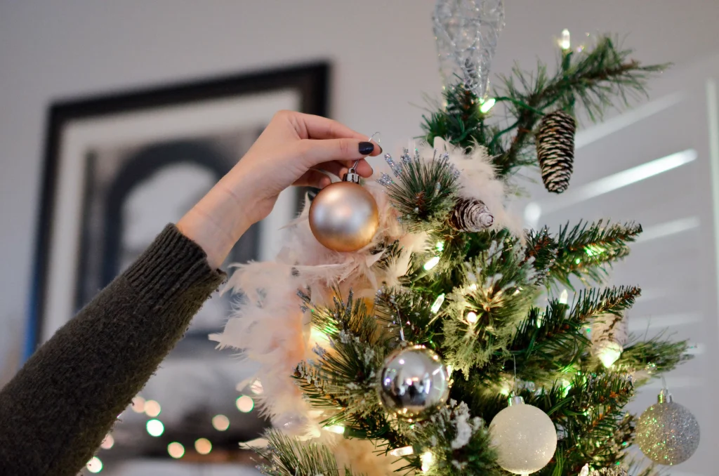 a person decorating the Christmas tree