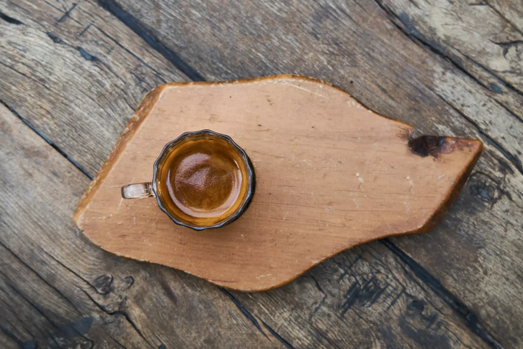 a cup of coffee served on a wooden plate