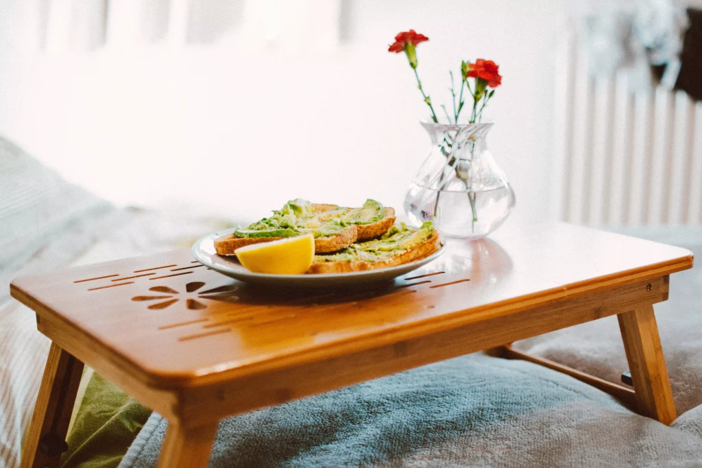 a little table in a bed with white sheets