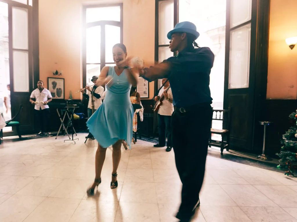 a guy wtih a hat and a girl in a blue dress dancing