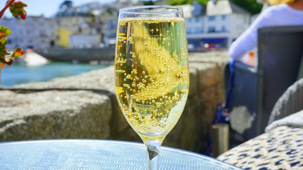 a glass full of sparkling water on a balcony next to the sea