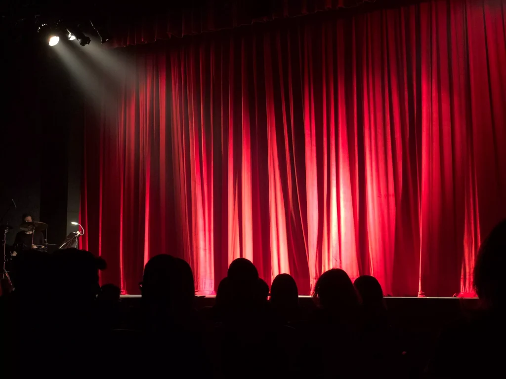 a stage in a theater with a red curtain