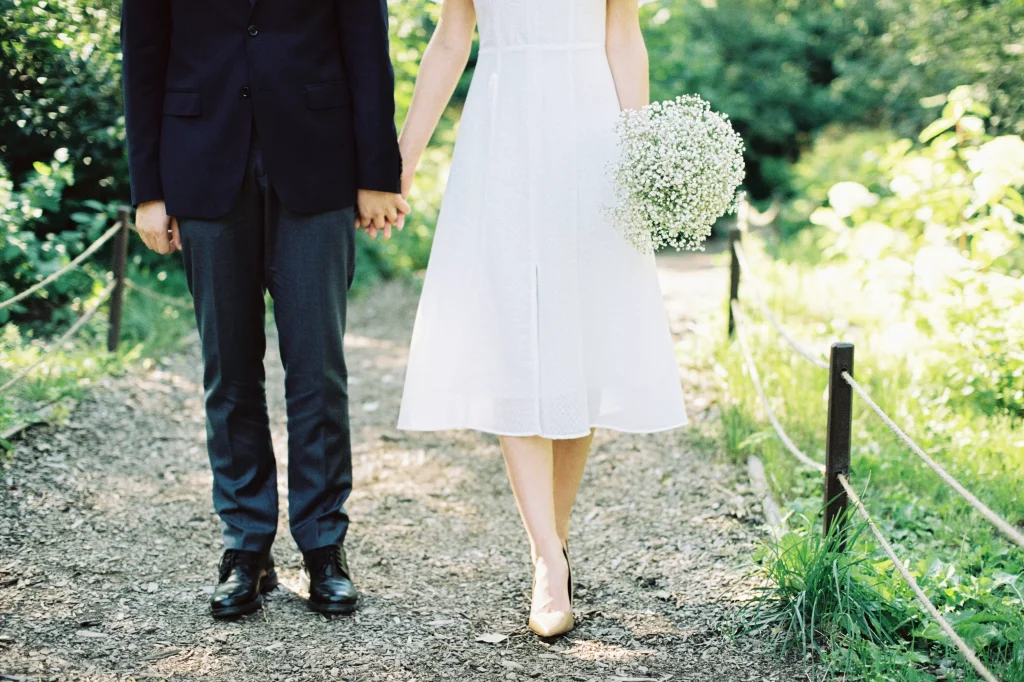 man in a suit and women in a dress holding flowers